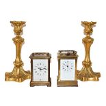 A pair of gilt bronze candlesticks with detachable nozzles, a brass carriage timepiece and another