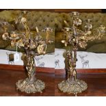 A pair of French Louis XVI style gilt metal four-branch candelabra surmounted by putti, raised on