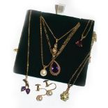 A diamond pendant on chain, both stamped '750', five gem set pendants on chains including a garnet