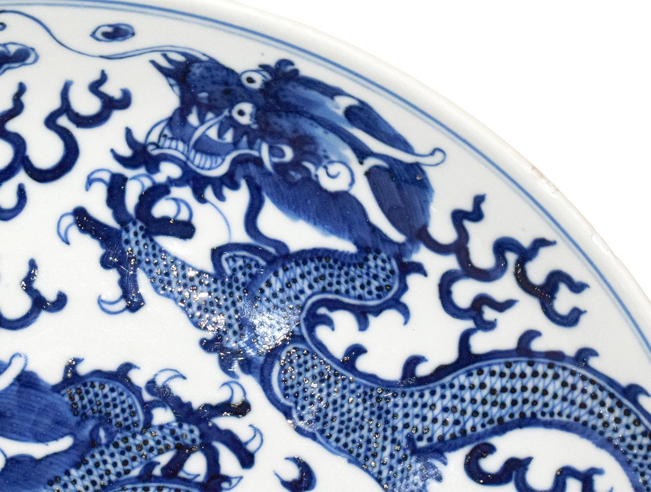 A 19th century Chinese blue and white dish, painted with dragons chasing pearls on grounds of - Image 3 of 8