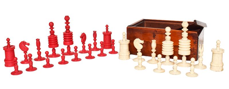 A 19th century carved and turned ivory chess set, the opposing side stained red and in mahogany