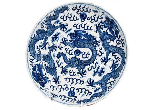 A 19th century Chinese blue and white dish, painted with dragons chasing pearls on grounds of