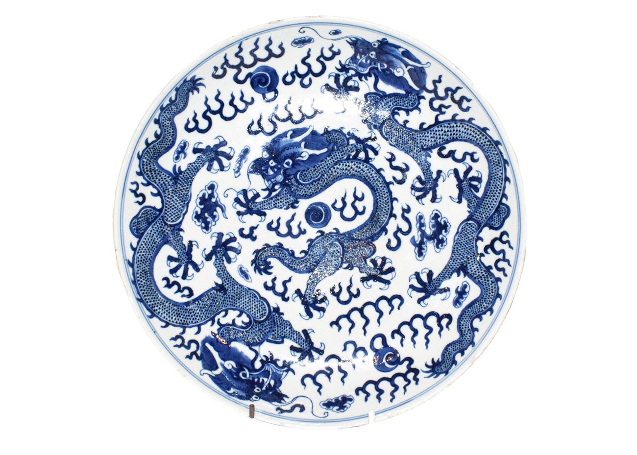 A 19th century Chinese blue and white dish, painted with dragons chasing pearls on grounds of - Image 2 of 8