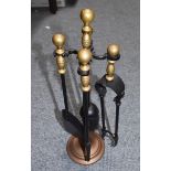 A small brass and iron fireside companion set