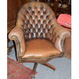 A brown leather Chesterfield style swivel armchair, 90cm by 80cm by 110cm