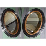 A pair of Edwardian ebonised and parcel gilt oval mirrors, 66cm by 87cm