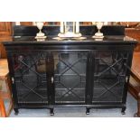 An early 20th century ebonised triple bookcase raised on square cabriole feet, 177cm by 46cm by