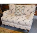 A modern country cottage sofa in stag print upholstery, 130cm by 96cm by 73cm