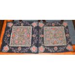 A matched pair of Rasht design embroideries, each on a black ground and of floral design, 48cm by