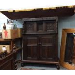 A 17th century oak court cupboard with foliate carved panel doors and turned supports (with