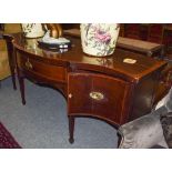 A George III mahogany serpentine fronted sideboard, banded in satinwood and raised on square