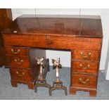 An early 20th century oak desk, the slanted front opening to reveal a fitted interior above a