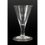 A Green Glass Wine Glass, circa 1750, the cup shaped bowl on hollow basal knop and baluster stem,