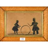An Early 19th Century Silhouette of Two Children Playing with a Hoop, highlighted in bronze, with