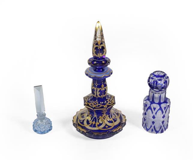 Three Glass Scent-Bottles, comprising: a gilt-heightened blue glass example, 19.5cm high; a cased