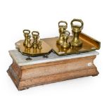 A Brass Balance, late 19th century, with rectangular and octagonal pans on a rectangular marble-