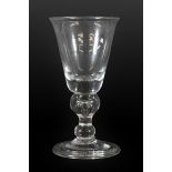 A Wine Glass, circa 1730, the rounded funnel bowl on a baluster stem with air tear and basal ball