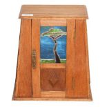 An Arts & Crafts Oak Table Cabinet, early 20th century, of tapering rectangular form, the panelled