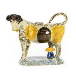 A Prattware Cow Creamer and Stopper, circa 1810, of traditional form with brown and ochre