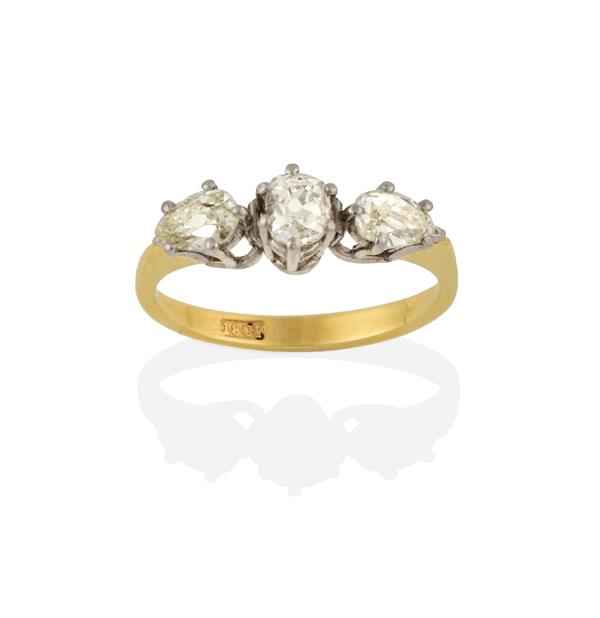 A Diamond Three Stone Ring, an old cut diamond flanked by pear shaped diamonds, in white claw