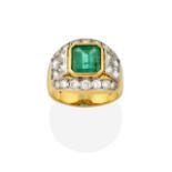 An Emerald and Diamond Ring, the emerald-cut emerald, flanked by princess cut diamonds, to a