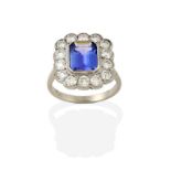 A Tanzanite and Diamond Cluster Ring, the emerald-cut tanzanite within a border of round brilliant