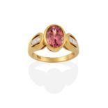 An 18 Carat Gold Garnet and Diamond Ring, the oval cut garnet in a yellow rubbed over setting, to