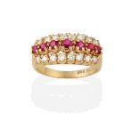 A Ruby and Diamond Ring, the graduated row of round cut rubies flanked by rows of round brilliant