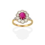 A Ruby and Diamond Cluster Ring, the oval cut ruby within a border of round brilliant cut