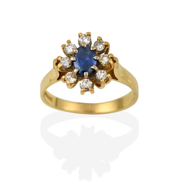 An 18 Carat Gold Sapphire and Diamond Cluster Ring, the oval cut sapphire, in white claw settings,