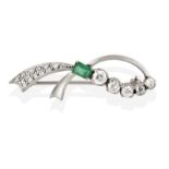 An Emerald and Diamond Brooch, realistically modelled as a white ribbon with an emerald-cut