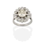 A Diamond Cluster Ring, the central round brilliant cut diamond within a border of baguette cut