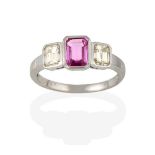 A Pink Sapphire and Diamond Three Stone Ring, the emerald-cut pink sapphire flanked by step cut