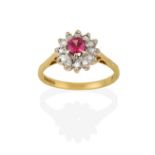 An 18 Carat Gold Pink Sapphire and Diamond Cluster Ring, the round cut pink sapphire within a border