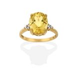 A 9 Carat Gold Heliodor Beryl and Diamond Ring, the oval cut heliodor flanked by trios of round