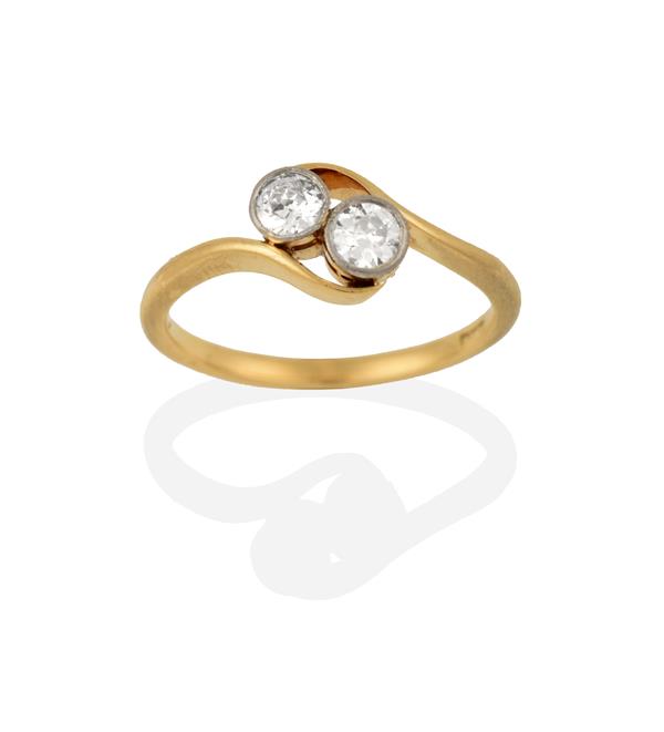 A Diamond Two Stone Twist Ring, the round brilliant cut diamonds in white millegrain settings, to