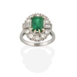 An Emerald and Diamond Cluster Ring, the emerald-cut emerald within a border of round brilliant