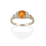 A Yellow/Orange Sapphire and Diamond Ring, the oval cut yellow sapphire flanked by pairs of round