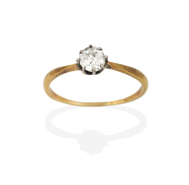 A Diamond Solitaire Ring, the round brilliant cut diamond in a white claw setting, to a yellow