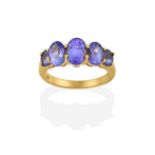 An 18 Carat Gold Tanzanite Five Stone Ring, the graduated oval cut tanzanites in yellow claw