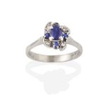 A Sapphire and Diamond Cluster Ring, the oval cut sapphire within an undulating border of eight-