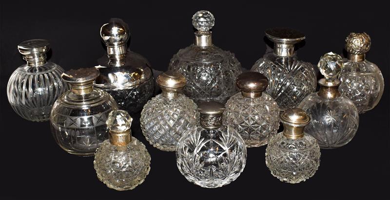 A collection of various silver-mounted glass scent-bottles, including one with a tortoiseshell