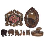 A group of carved wooden articles including Black Forest style bears, leaf carved mirror, a carved