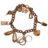 A 9 carat gold curb link bracelet, hung with various charms including a telephone box, a trowel, a