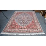 An Indian carpet, the ice blue field of scrolling vines around a stepped medallion, framed by