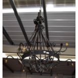 A black painted wrought metal chandelier with scrolling decoration, diameter 115cm, drop