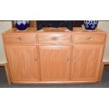 An Ercol light elm Windsor sideboard, with three drawers over three cupboard doors, 155cm by 44cm by