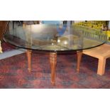 A modern circular glass top dining table raised on a turned walnut base, 175cm by 76cmNo chips or