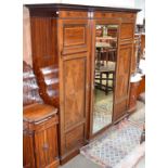 An Edwardian mahogany breakfront triple wardrobe crossbanded in satinwood, the central section