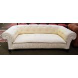 An Edwardian Chesterfield style two-seater sofa with cream silk upholstery, raised on cabriole feet,